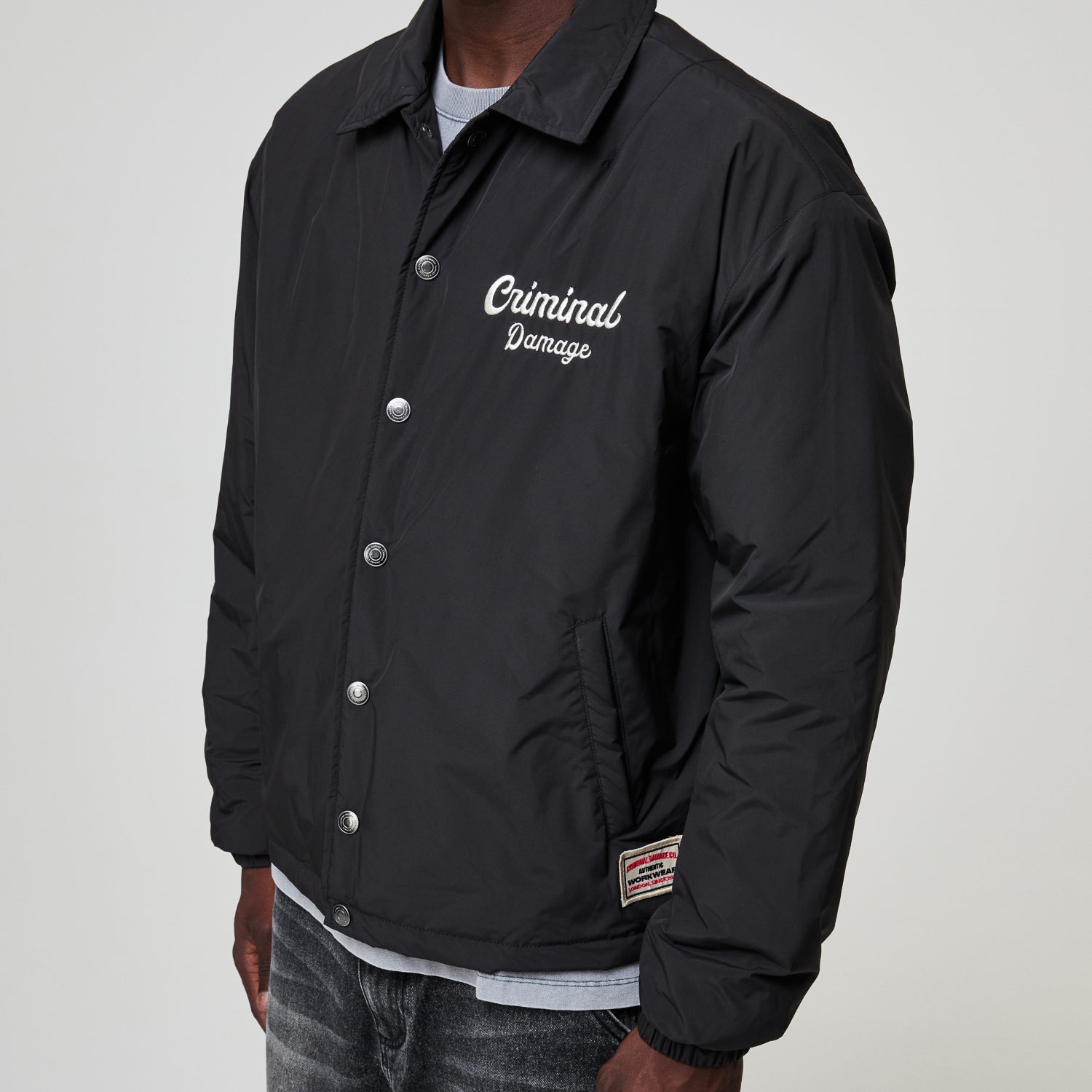 Black jacket with 'Criminal Damage' text on a plain background