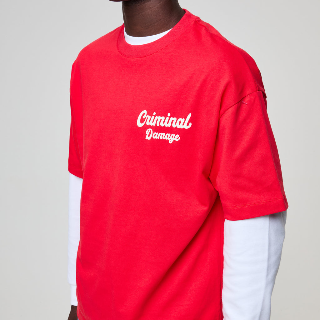Red t-shirt with 'Criminal Damage' text worn by a person on a plain background