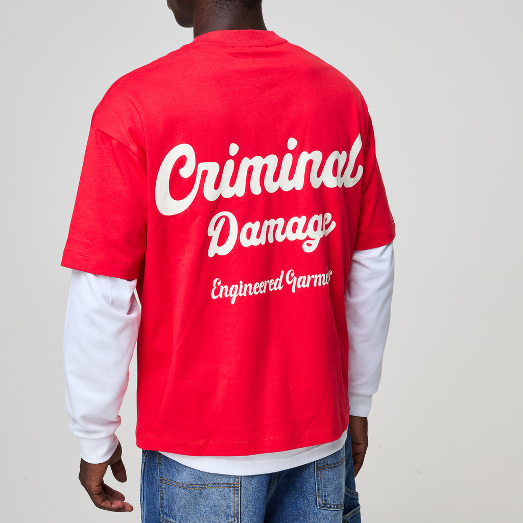 Red 'Criminal Damage' shirt worn by a person on a plain background