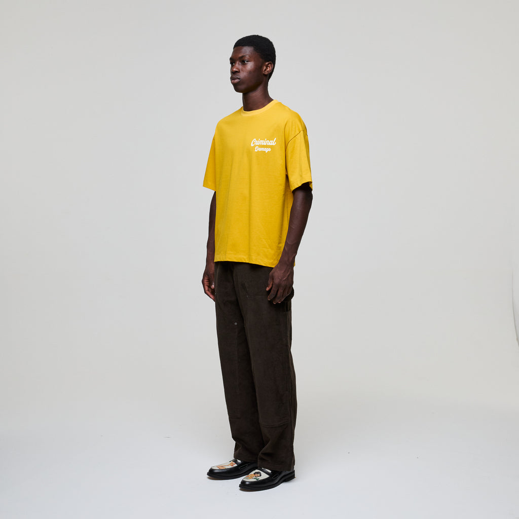 Person wearing a yellow t-shirt with text on a white background