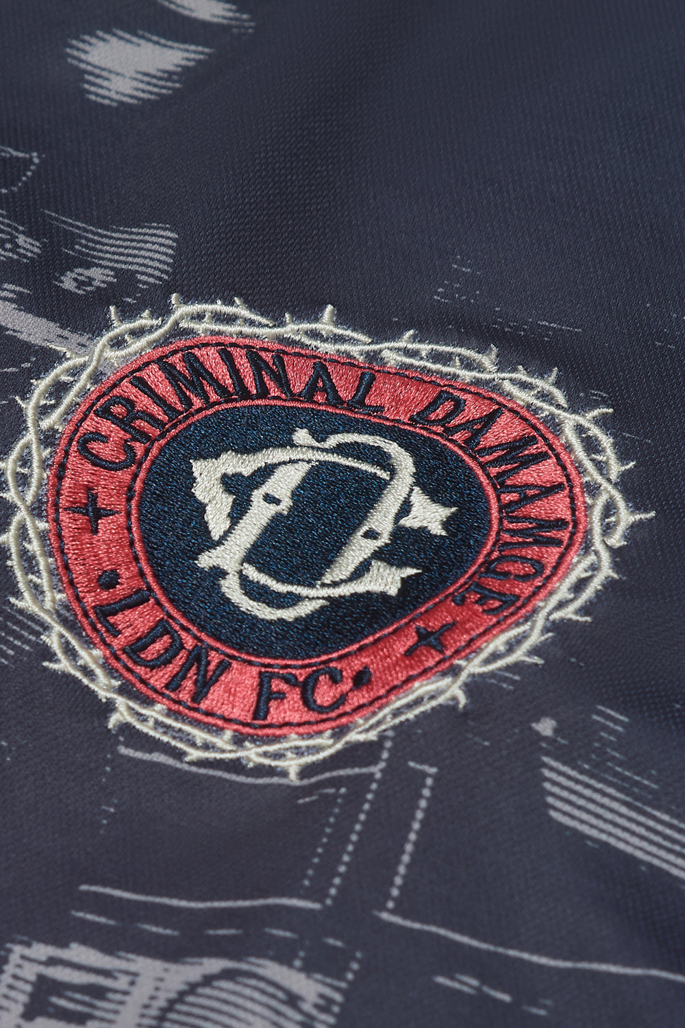 Close up of Criminal Damage embroidered path on football shirt