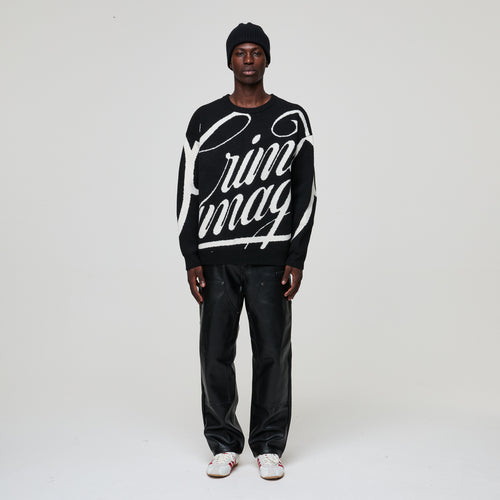 Person wearing a black sweater with white text on a plain background