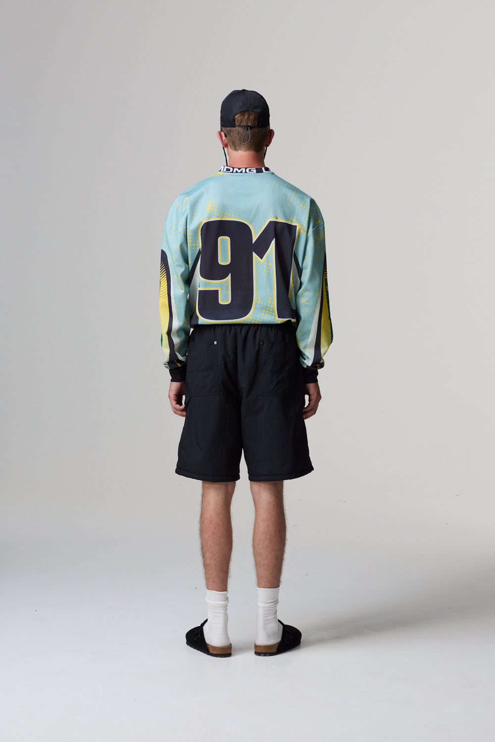 Person wearing a colourful Criminal Damage jersey with the number 91 on a grey background