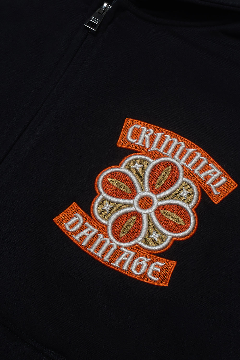 Close up of Criminal Damage embroidered patch on hoodie