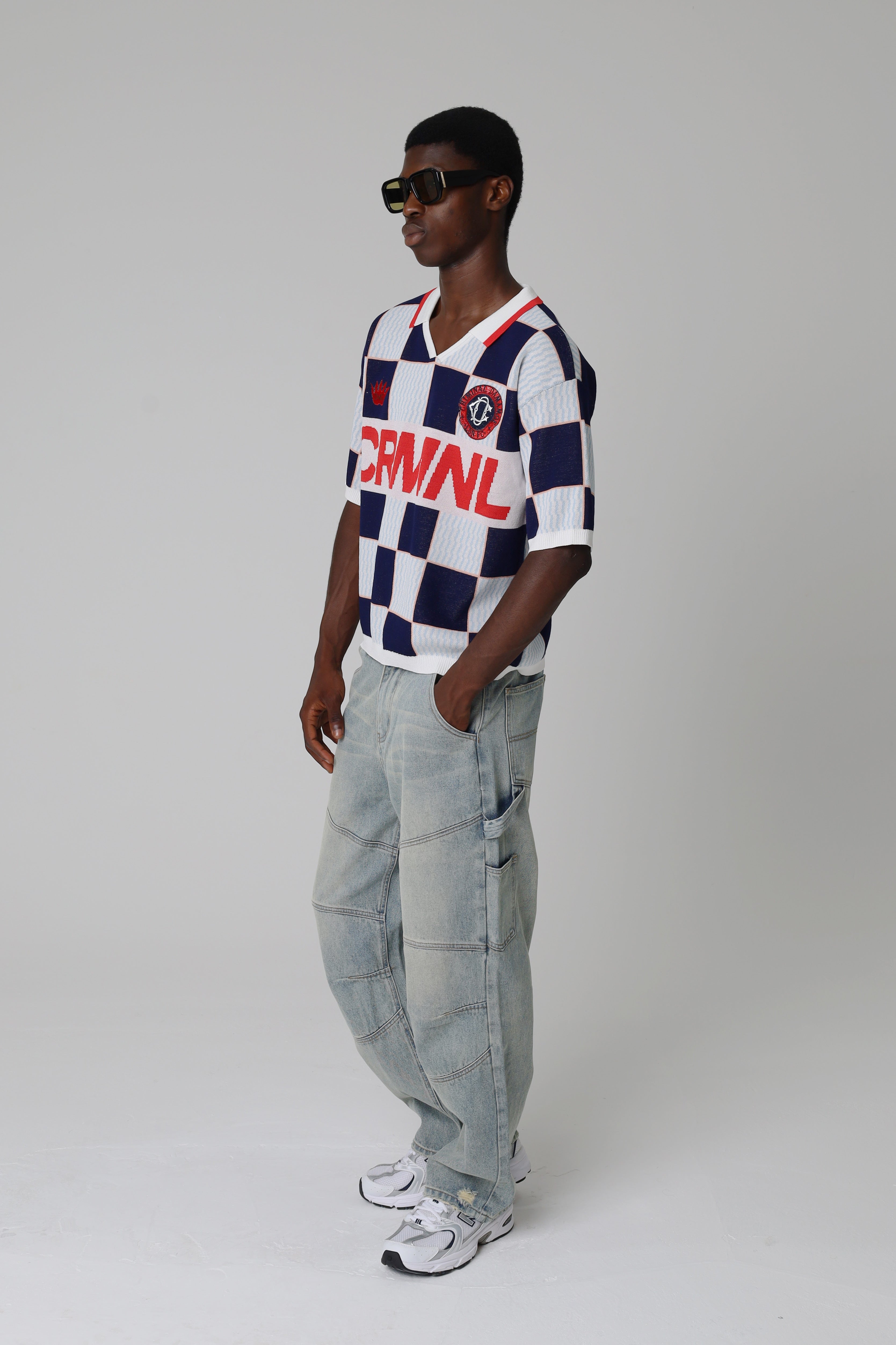 Model wearing a Criminal Damage checkered jersey with visible branding on a grey background