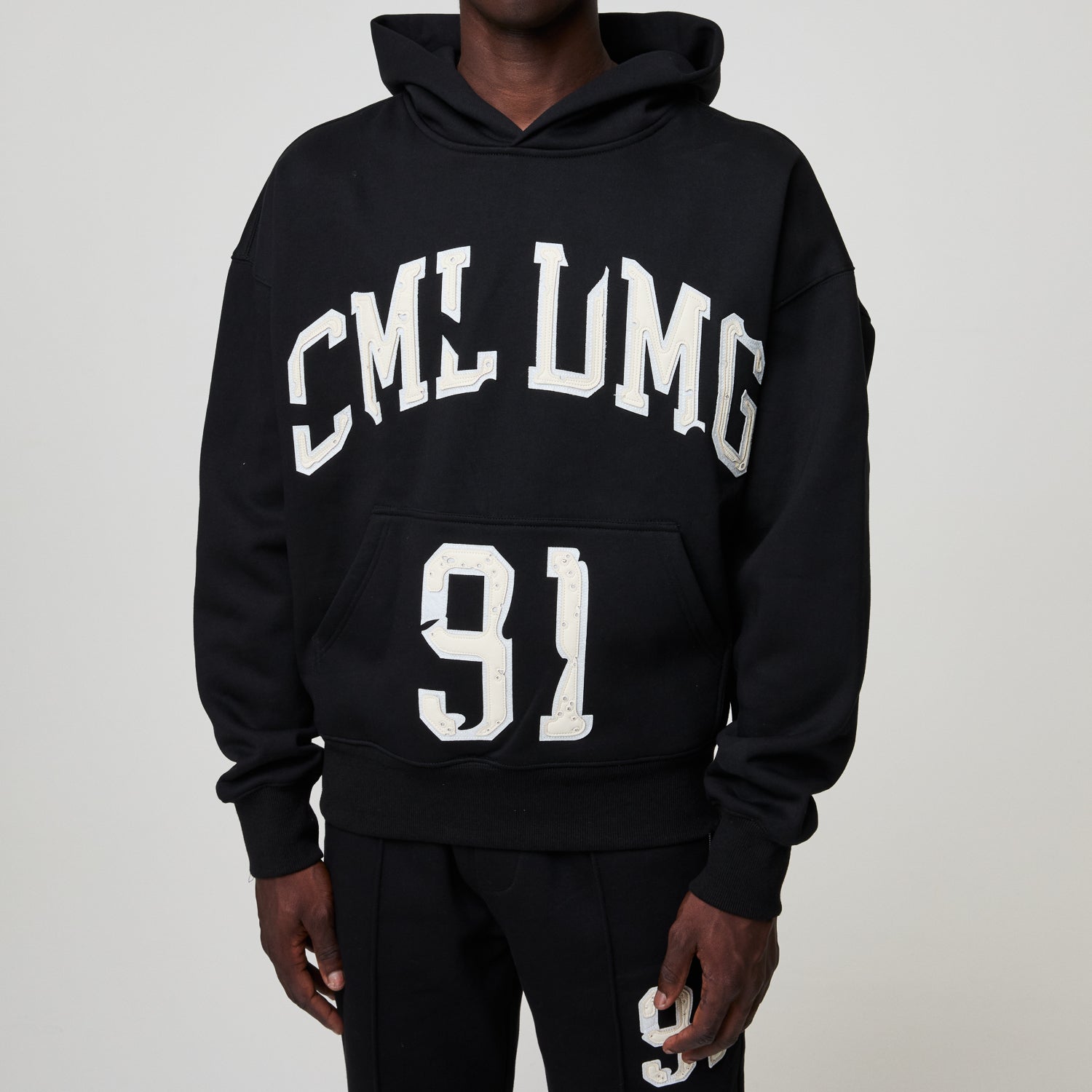 Black hoodie with 'CML LMG 91' text on a plain background