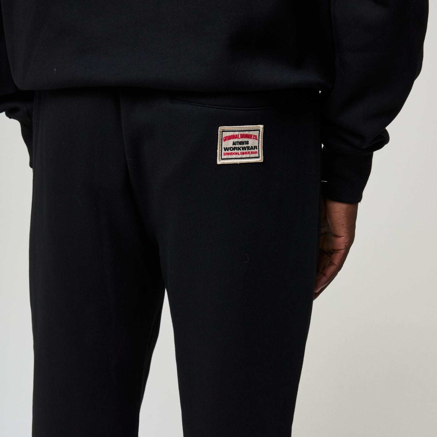 Black pants with a visible brand label on a light gray background