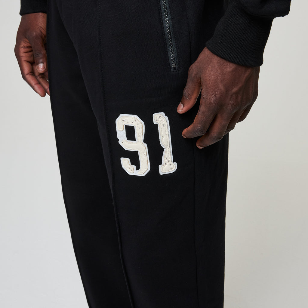 Black pants with white number '91' on a plain background