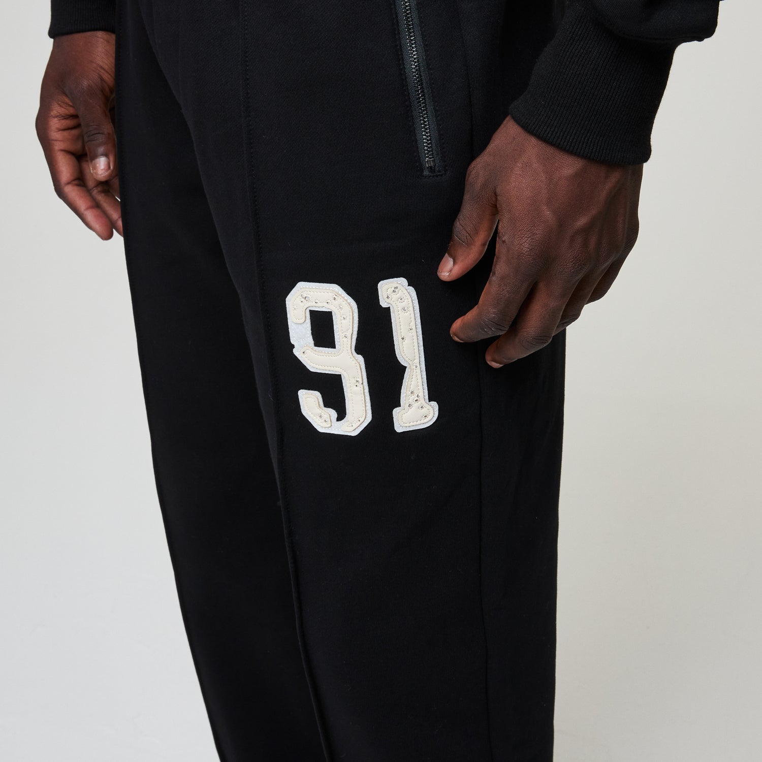 Black pants with white number '91' on a plain background