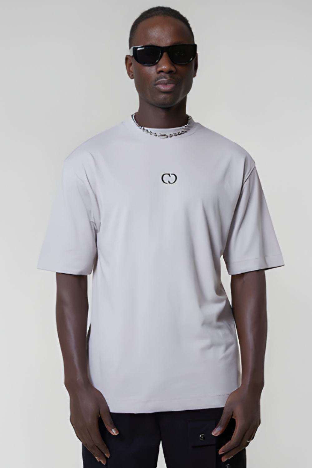 Person wearing a white t-shirt with a logo on the back against a plain background