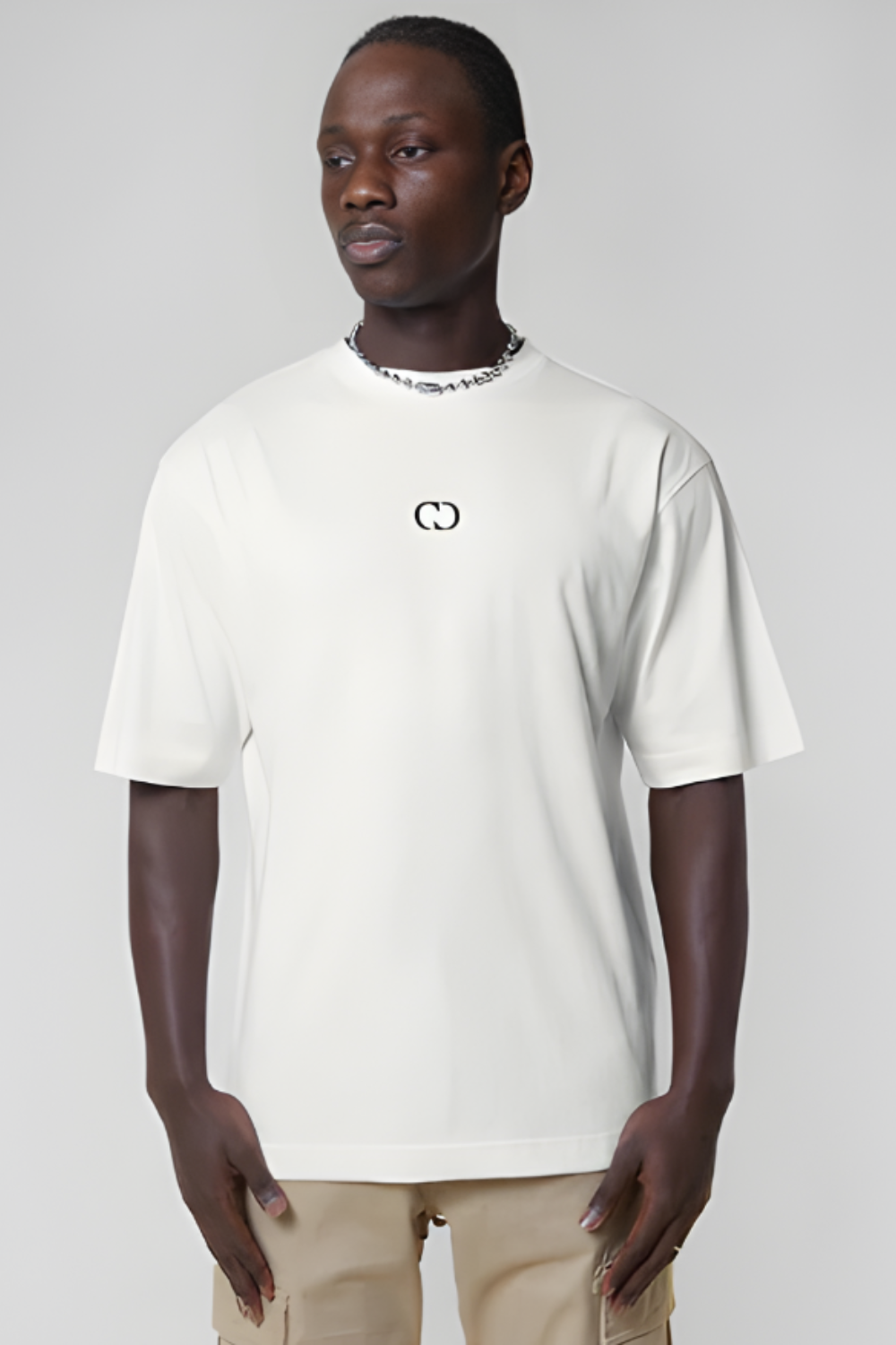 Man wearing a white t-shirt with a logo on a plain background