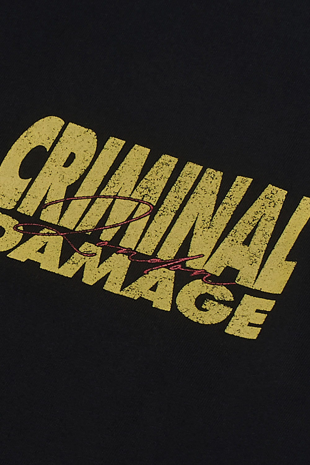 Close up of Criminal Damaging graphic on black t-shirt