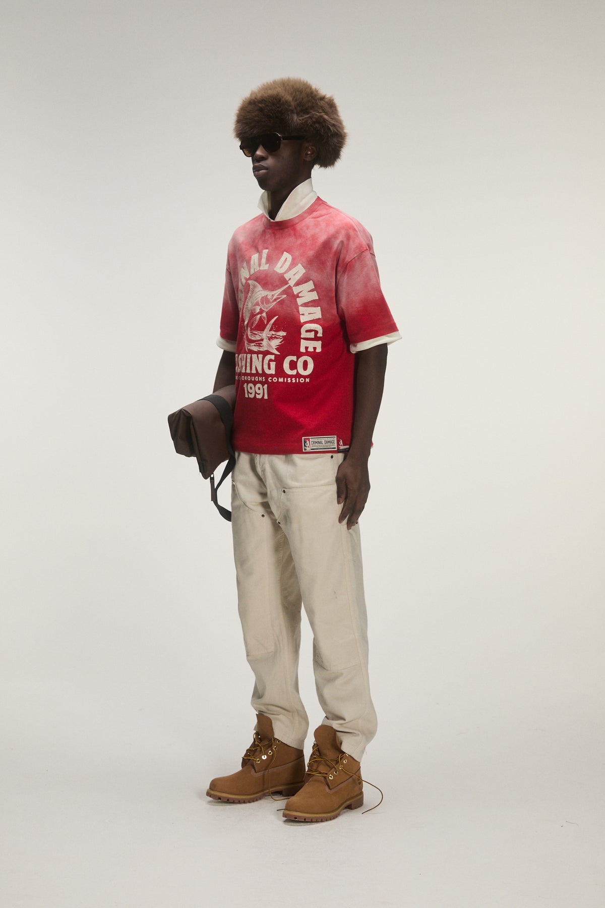 Male model wearing criminal damage t-shirt on white background