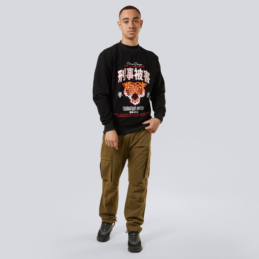 Person wearing Criminal Damage cargo pants with a dragon graphic standing against a plain background