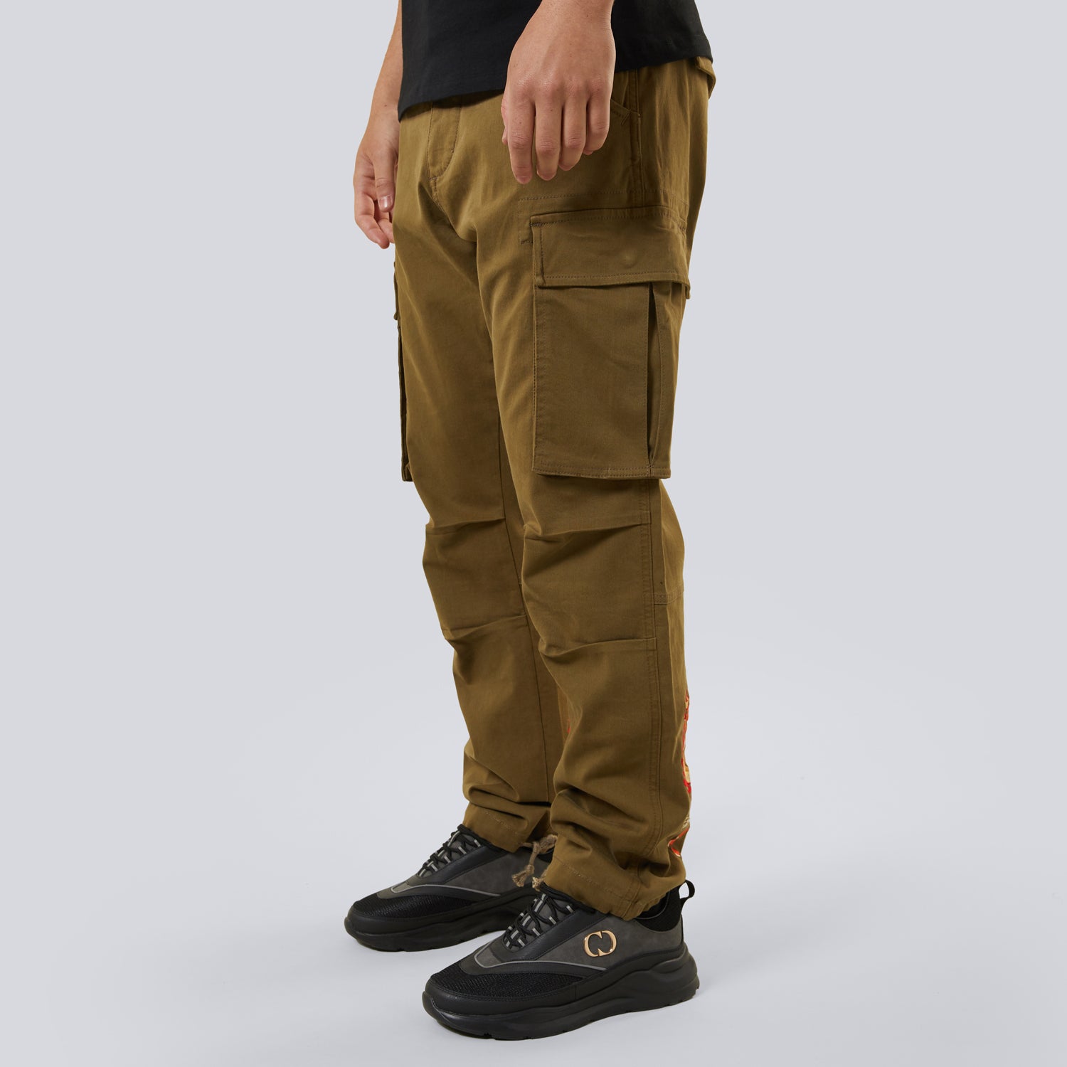 Person wearing brown cargo pants on a white background