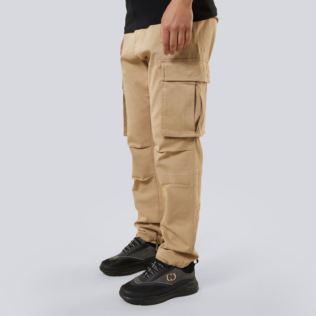 Beige cargo pants worn by a person on a light gray background