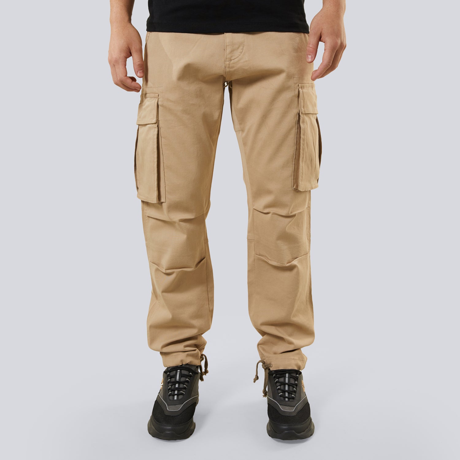 Beige cargo pants worn by a person on a light gray background