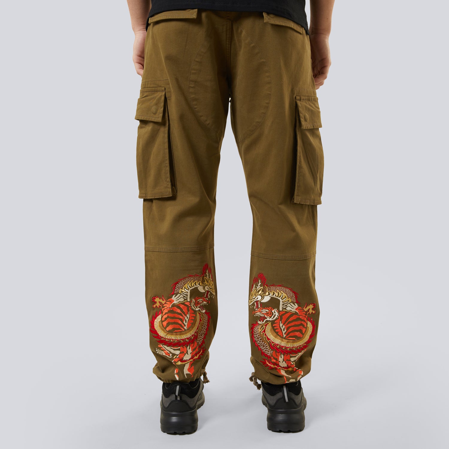 Brown cargo pants with dragon embroidery on a white background