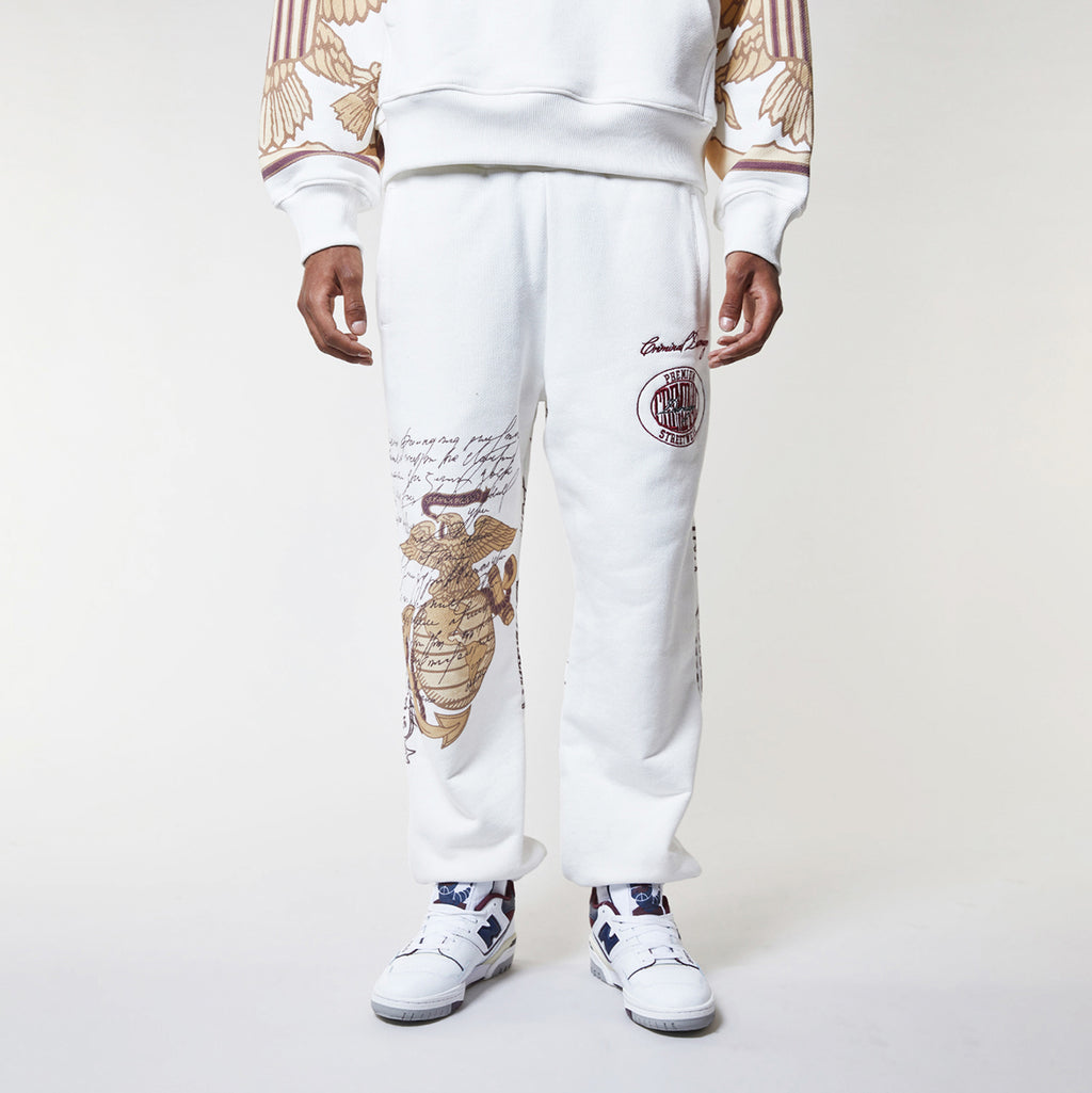 Person wearing a white outfit with seashell patterns on a plain background
