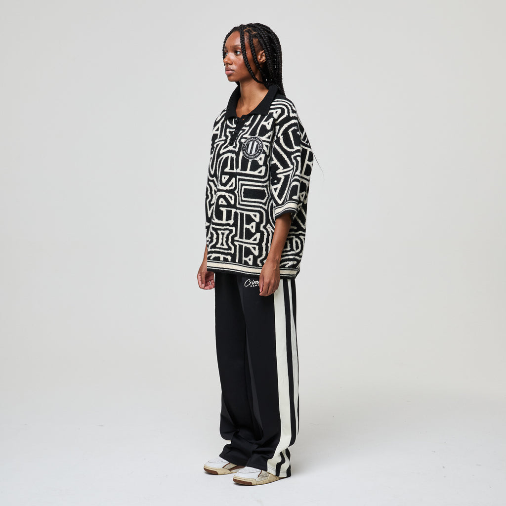 Person wearing a black and white patterned outfit on a plain background