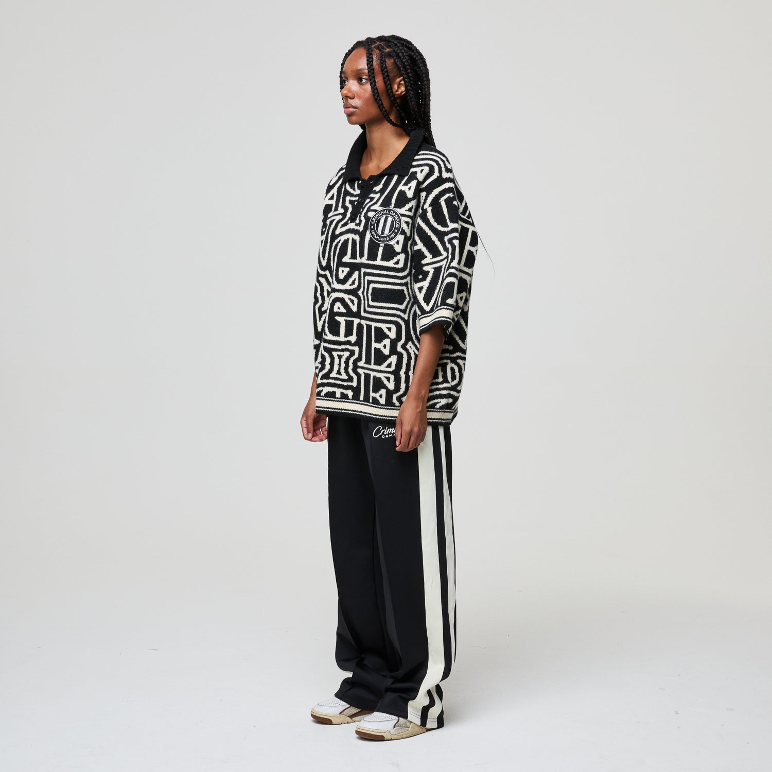 Person wearing a black and white patterned outfit on a plain background