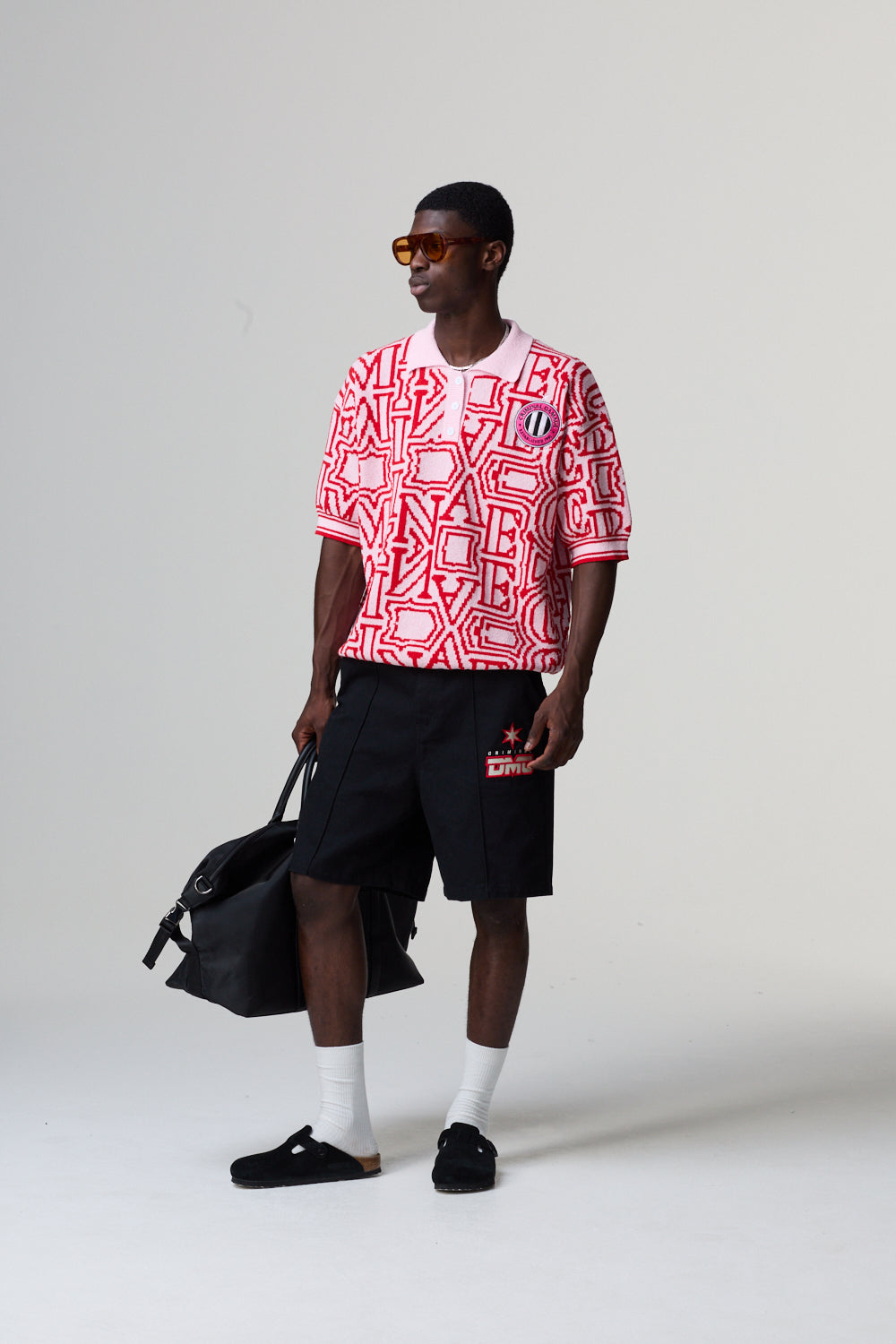 Model wearing a red and white Criminal Damage patterned shirt with black shorts on a grey background