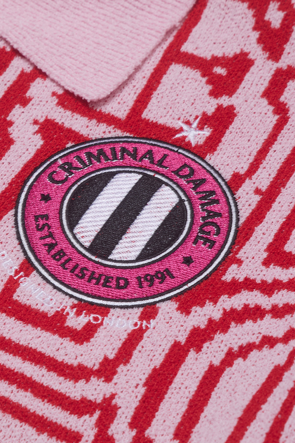 Close up of Criminal Damage branding patch on polo shirt