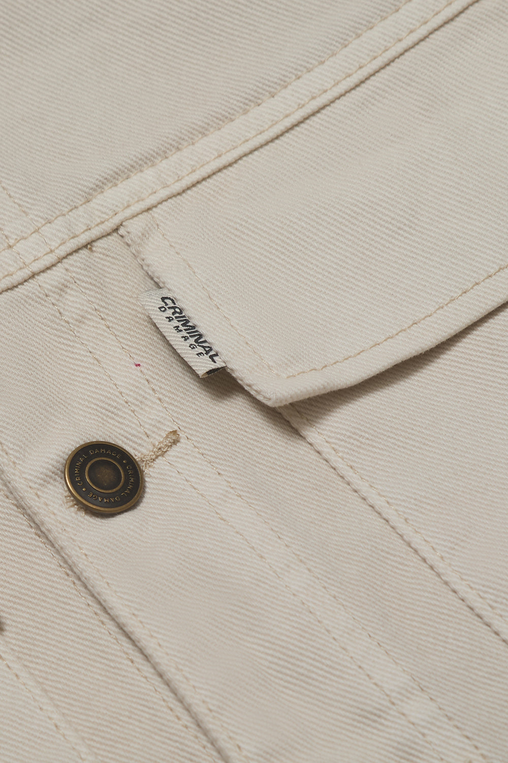 Close up of Criminal Damage button and brand label on button up shirt