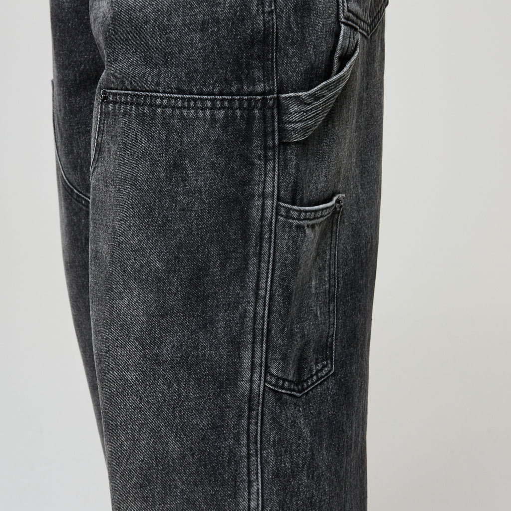 Close-up of black jeans on a light gray background