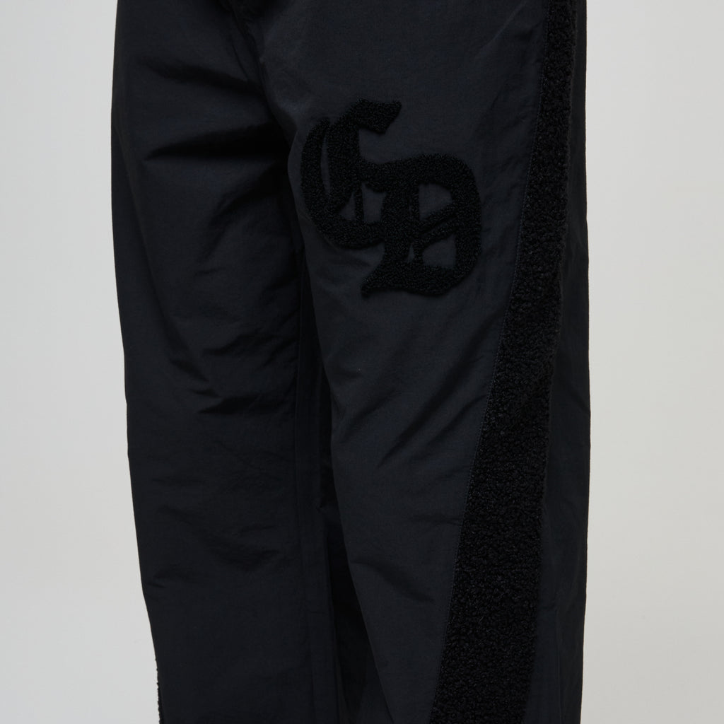 Black pants with a logo on a light gray background