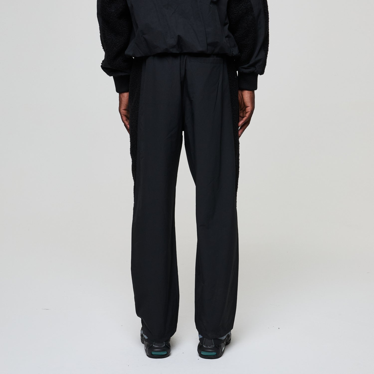 Person wearing a black outfit on a white background