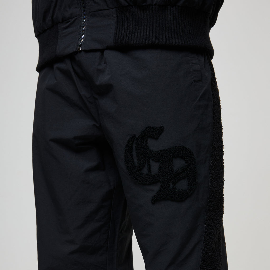 Black pants with a logo on a light gray background