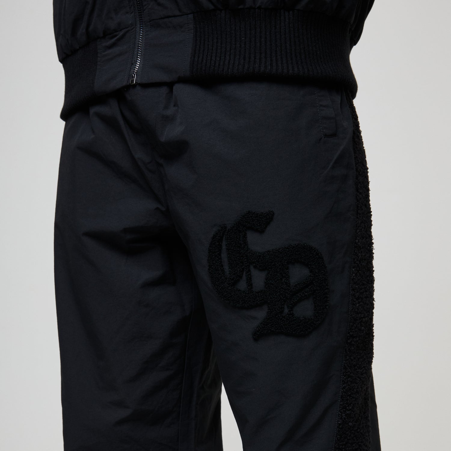Black pants with a logo on a light gray background