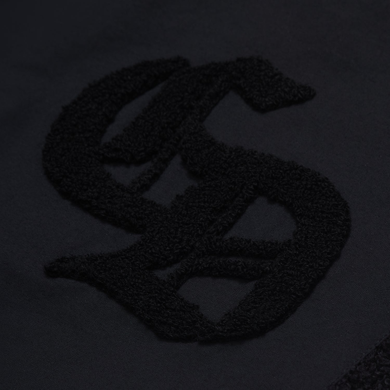Black textured logo on a dark background