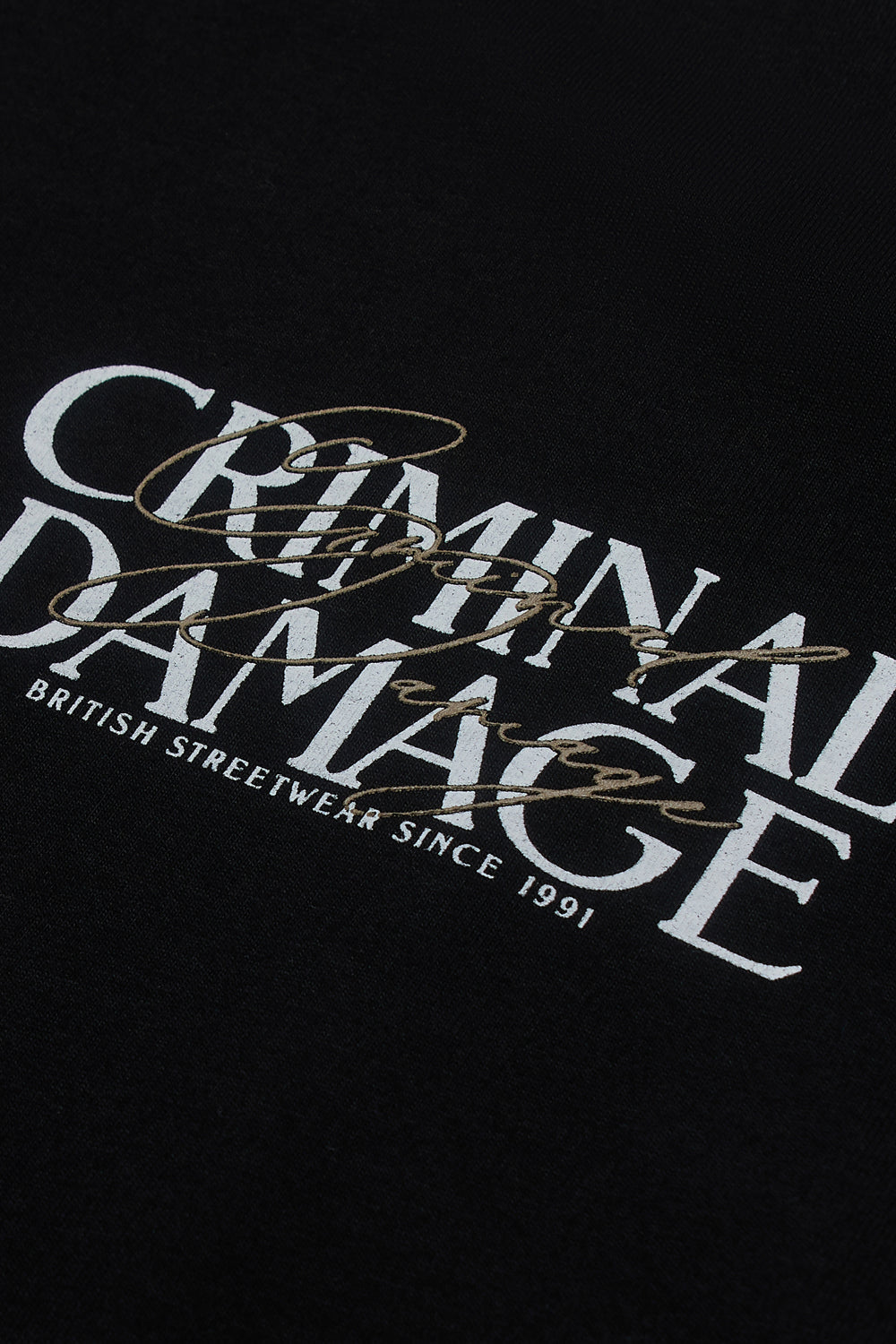 Close up of Criminal Damage logo on black t-shirt