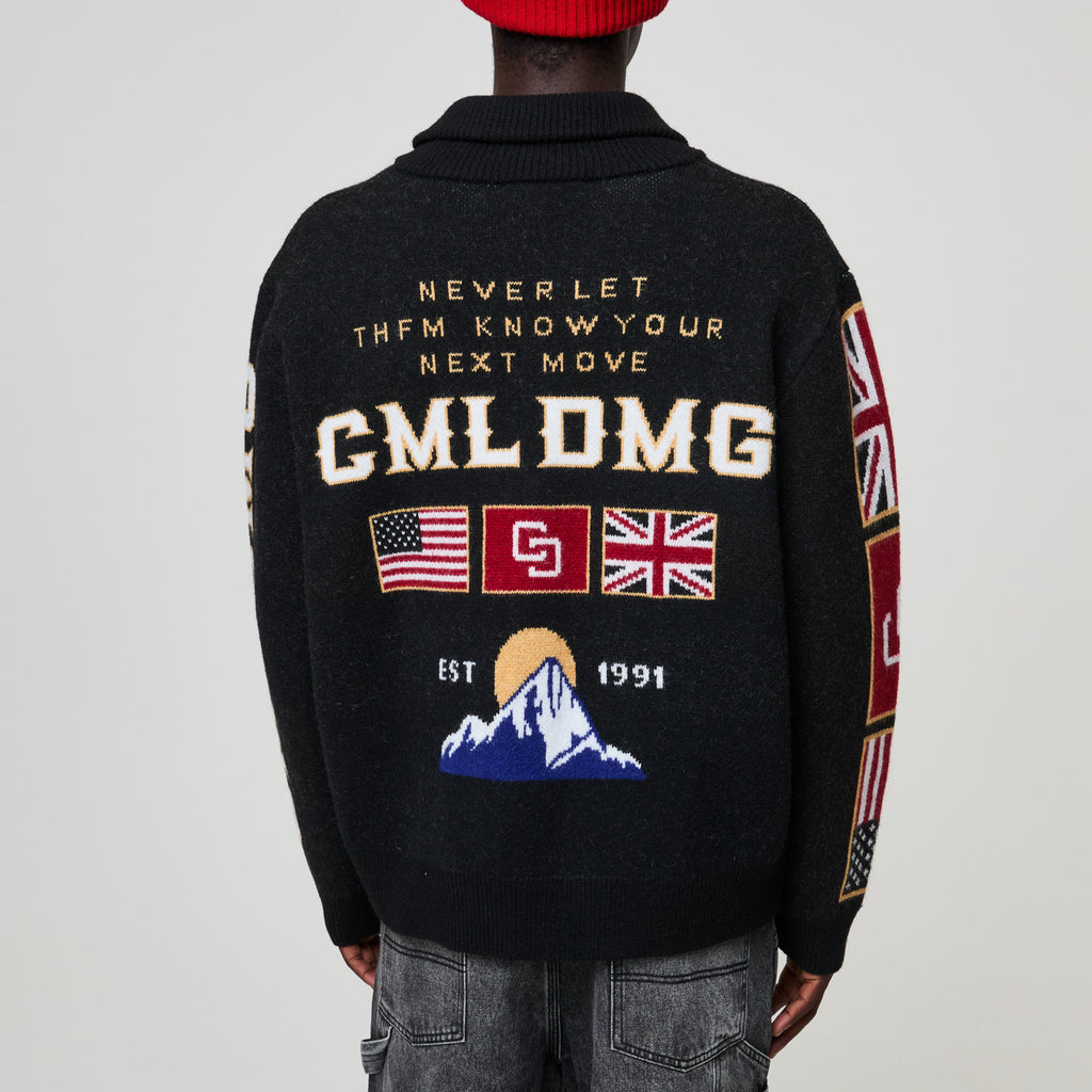 Black sweater with text and flags on the back, worn by a person.