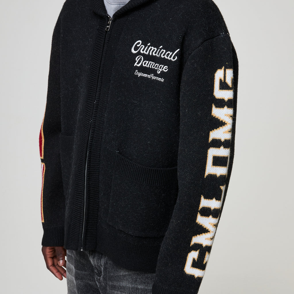 Black zip-up hoodie with 'Criminal Damage' branding on a gray background