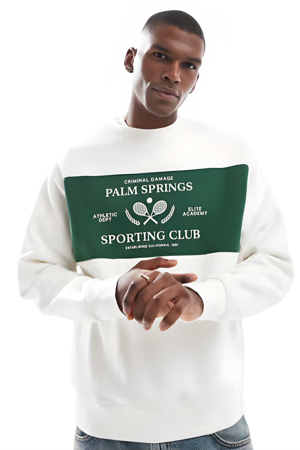 Man wearing a white Criminal Damage sweatshirt with a green graphic design on a white background