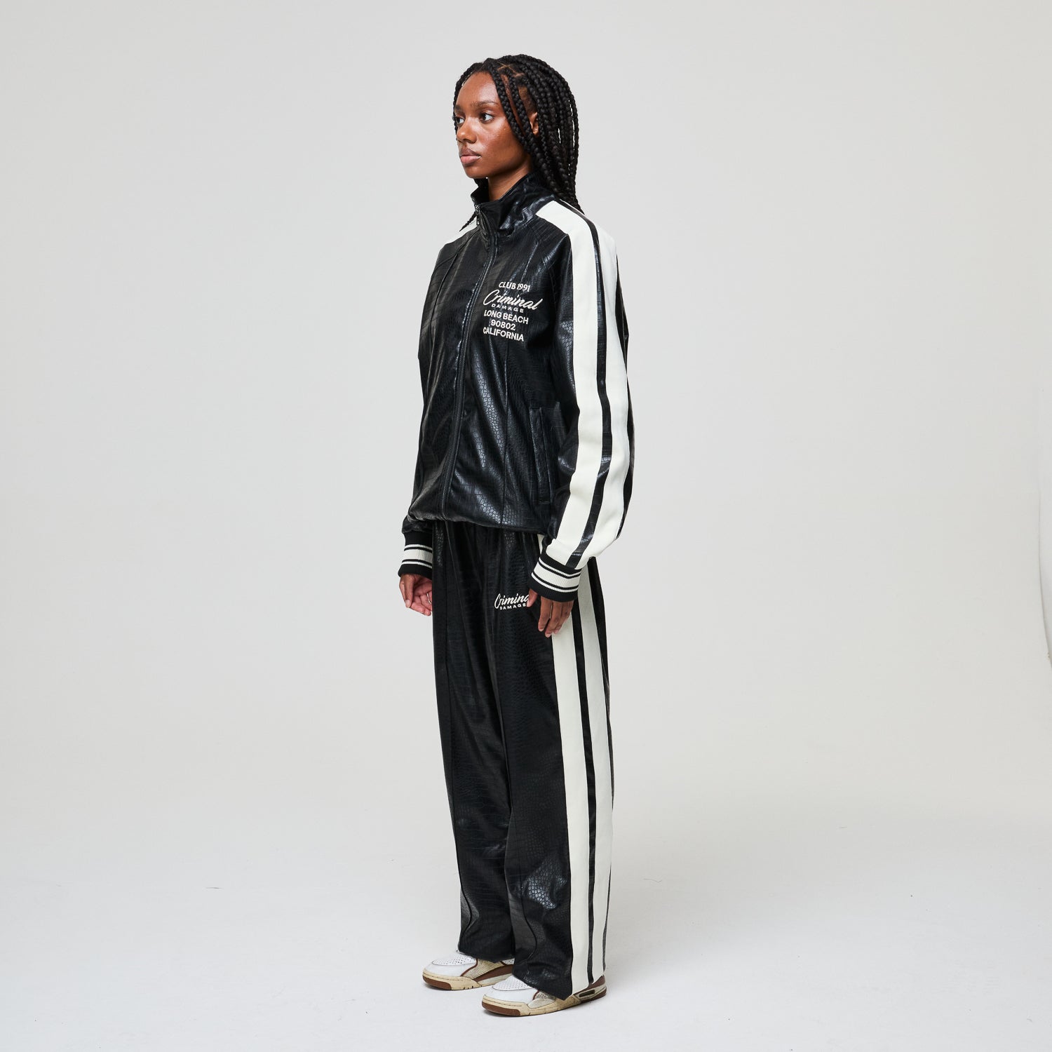 Person wearing a black and white tracksuit with visible branding on a plain background