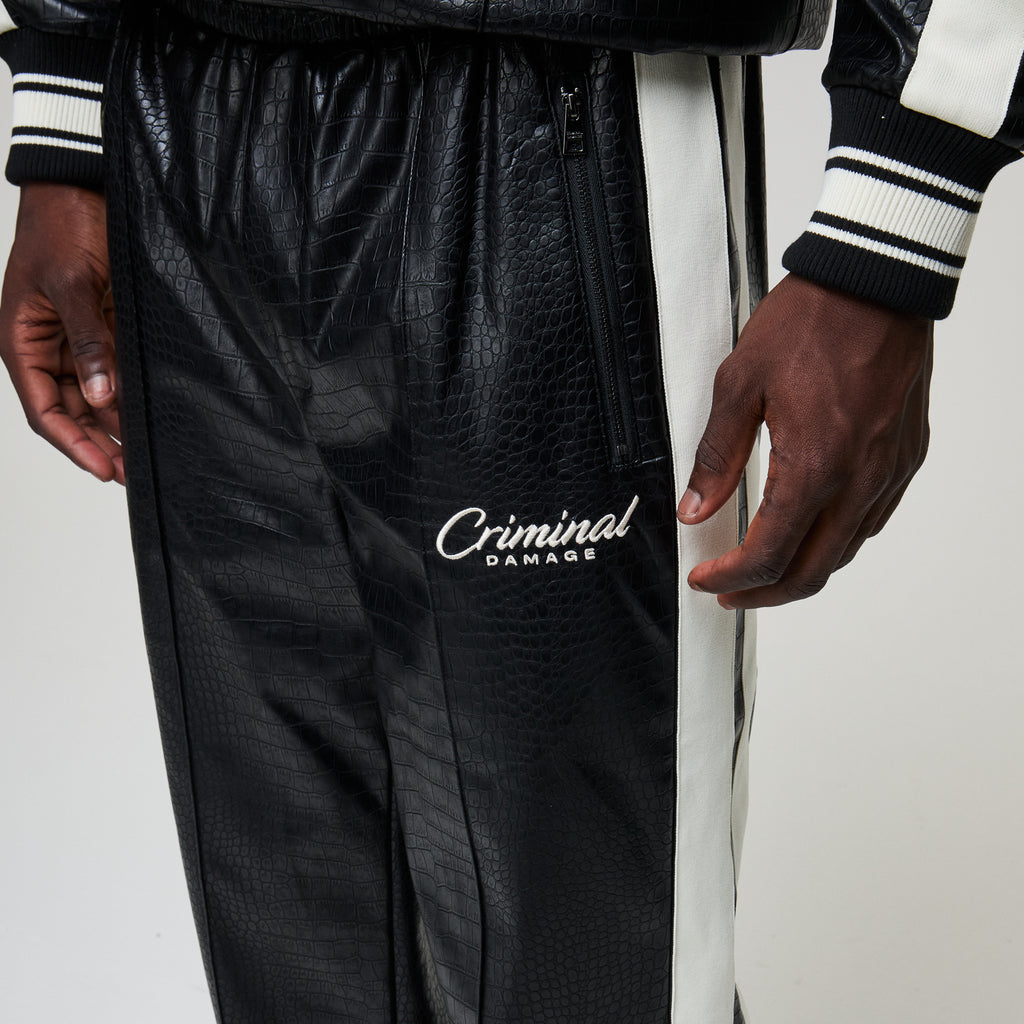 Black leather pants with 'Criminal Damage' branding 