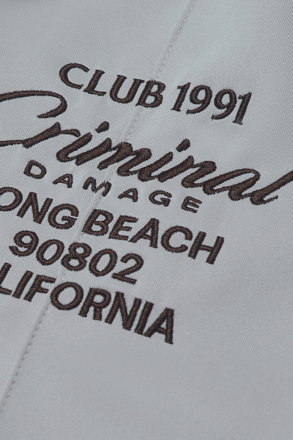 Close up of Criminal Damage embroidered branding on pants