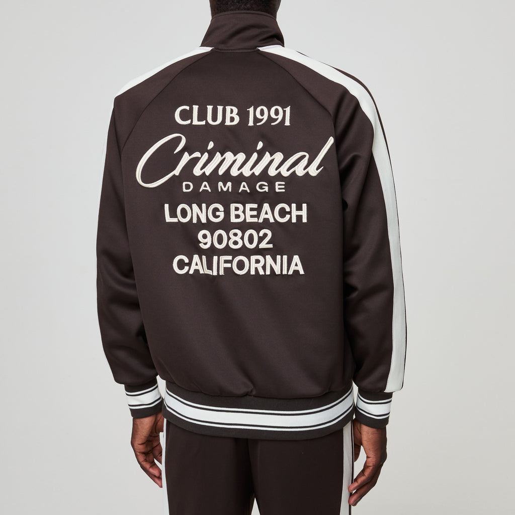 Black tracksuit with white text on the back against a gray background