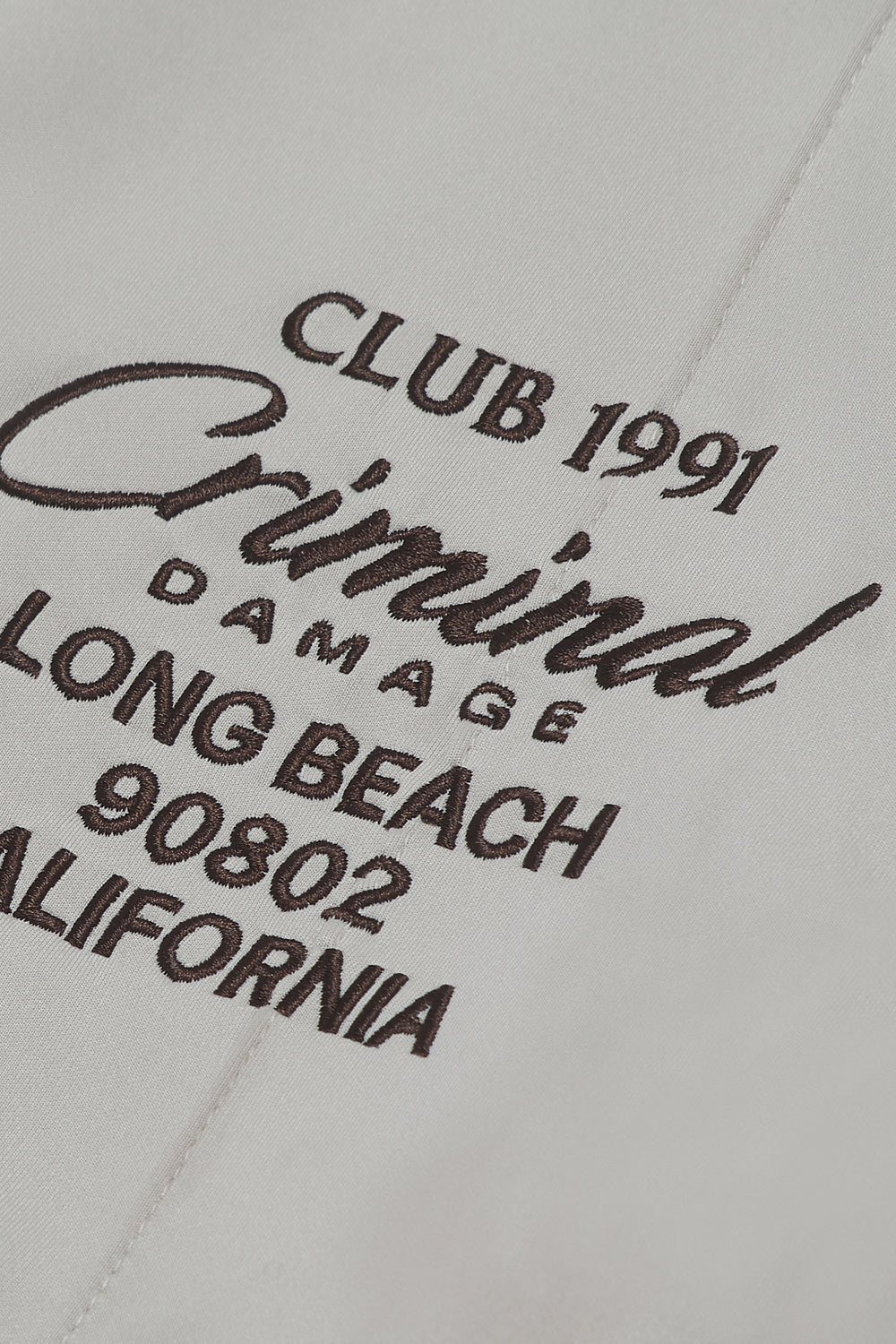 Close up of embroidered Criminal Damage branding on zip up jacket