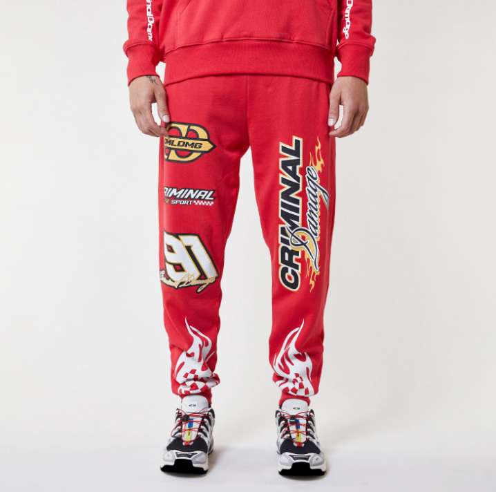 Red Criminal Damage tracksuit with brand logos on a white background
