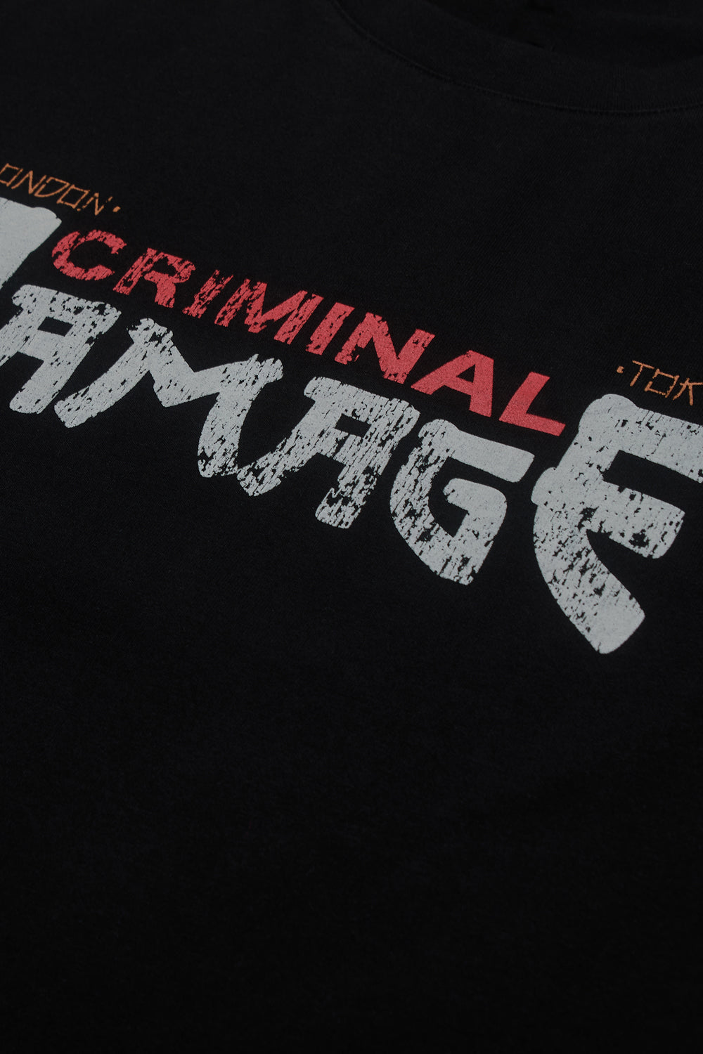 Close up of Criminal Damage written graphic on t-shirt