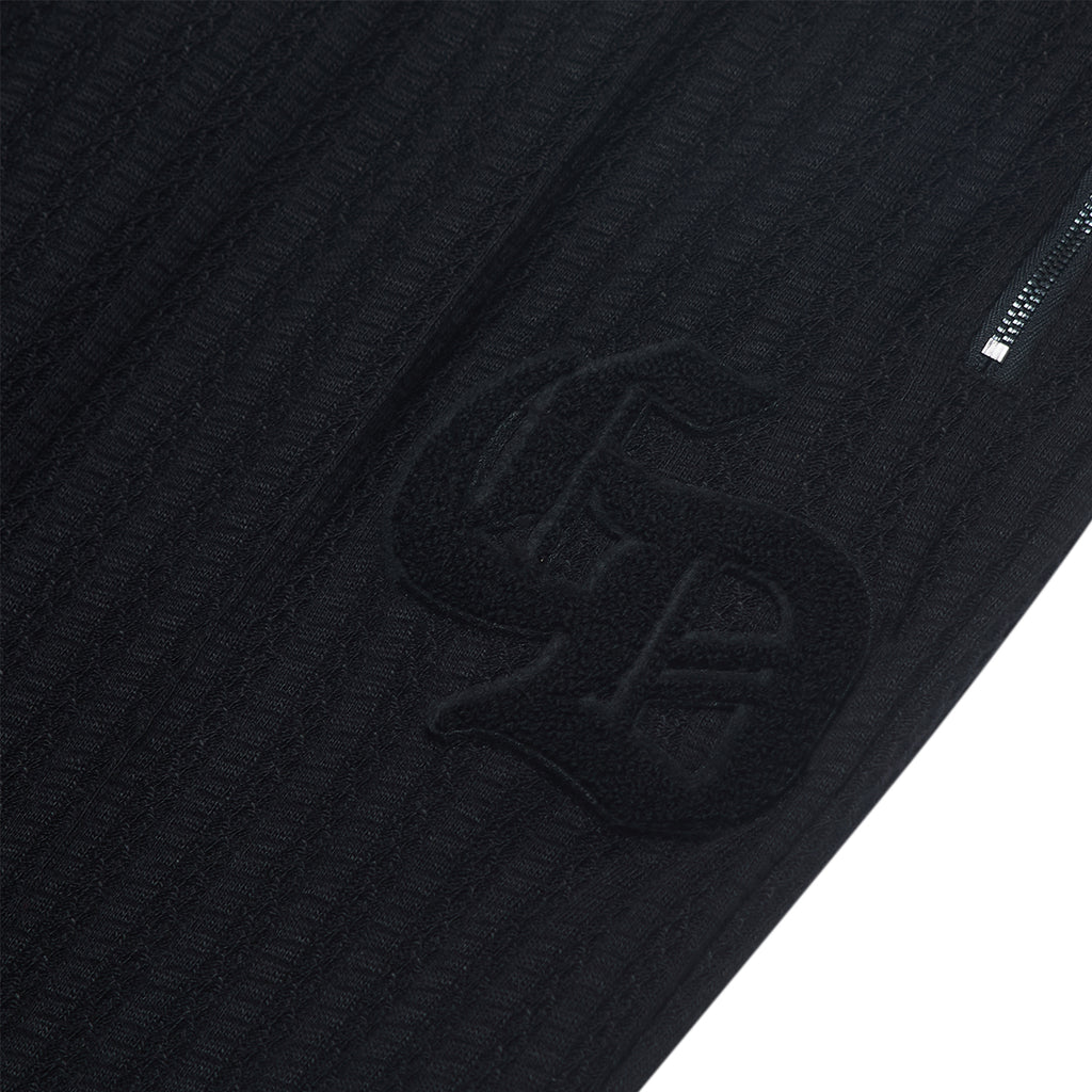 Close-up of a textured black jacket with a logo on a white background