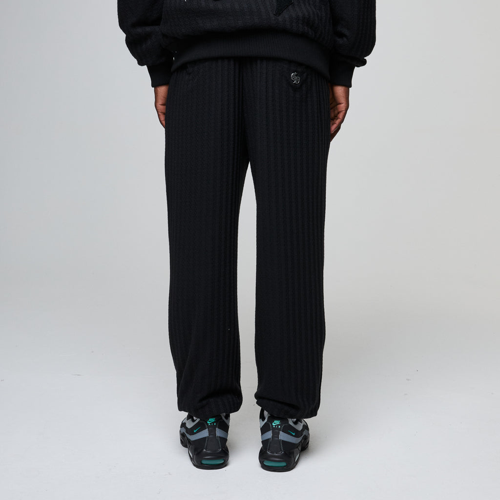 Person wearing black pinstripe pants on a white background