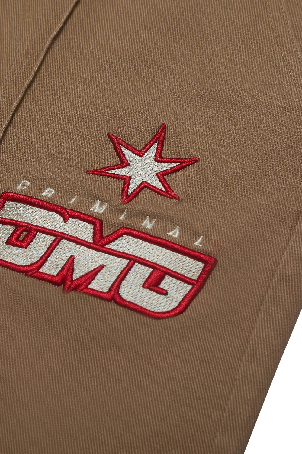 Close up of Criminal Damage embroidered patch logo on white background