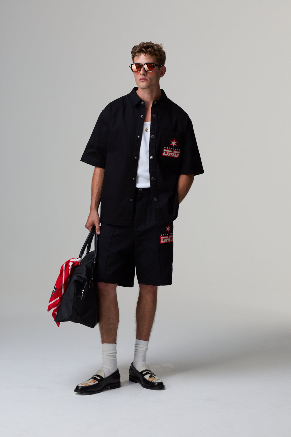 Man wearing a black shirt and shorts with a white background