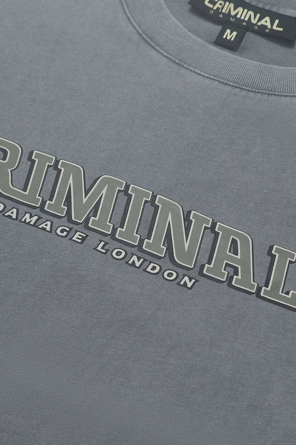 Close up of Criminal Damage branding on t-shirt